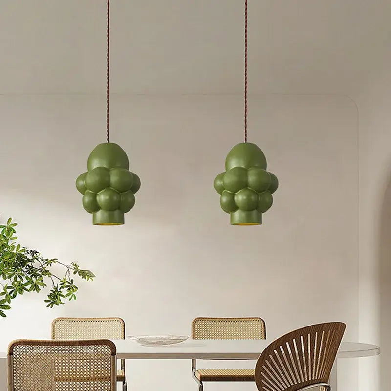 Two olive-green bubble-shaped decorbites creamy wind led pendant lights hang by braided cords for dining room lighting