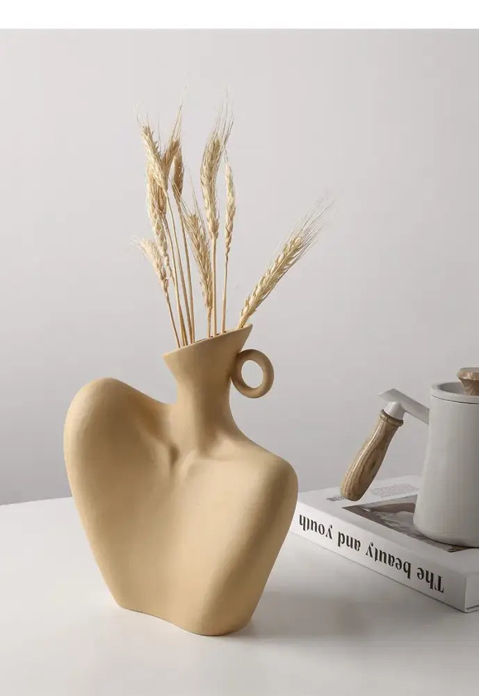 Beige ceramic human vase with sculpted organic form and circular handle for stylish home decor by DecorBites