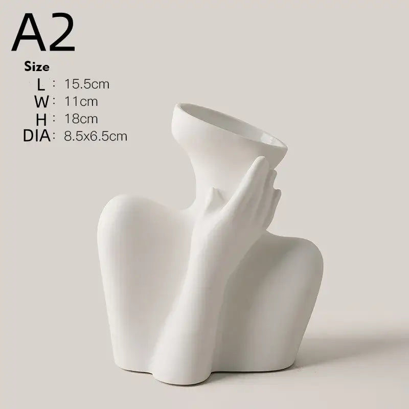 White ceramic sculpture of a hand gently cradling the neck of a ceramic human vase for home decor by DecorBites™