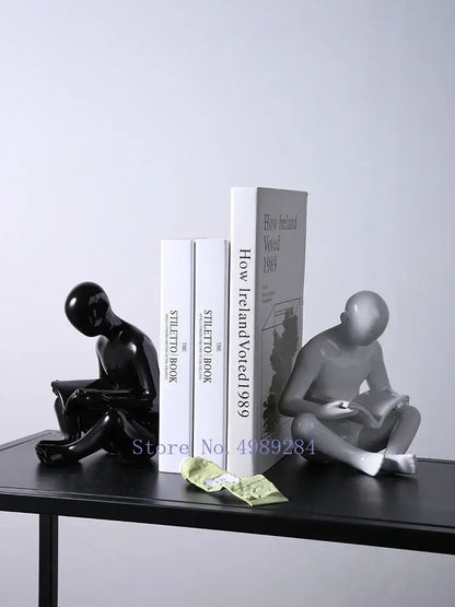 Black and silver glossy ceramic bookends shaped like seated human reading figures by decorbites creative ceramics