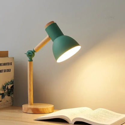 Teal creative nordic table lamp with wooden base and articulated arm casting warm light over an open book