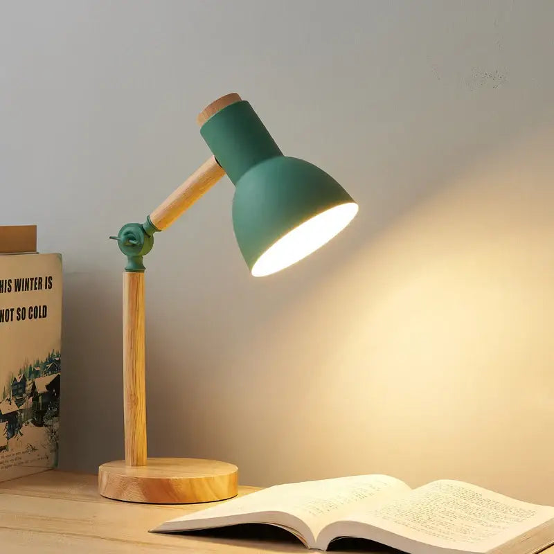 A teal creative nordic table lamp with wooden base and articulated arm casting warm light over open book