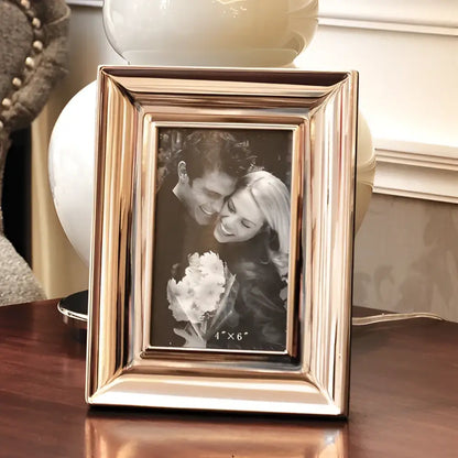 A rectangular brushed gold-toned metal photo frame with subtle vertical grooves in decorbites crocodile leather modern style