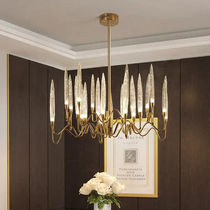Gold-toned decorbites crystal branch chandelier with slender transparent glass arms resembling candle flames for dining room lighting