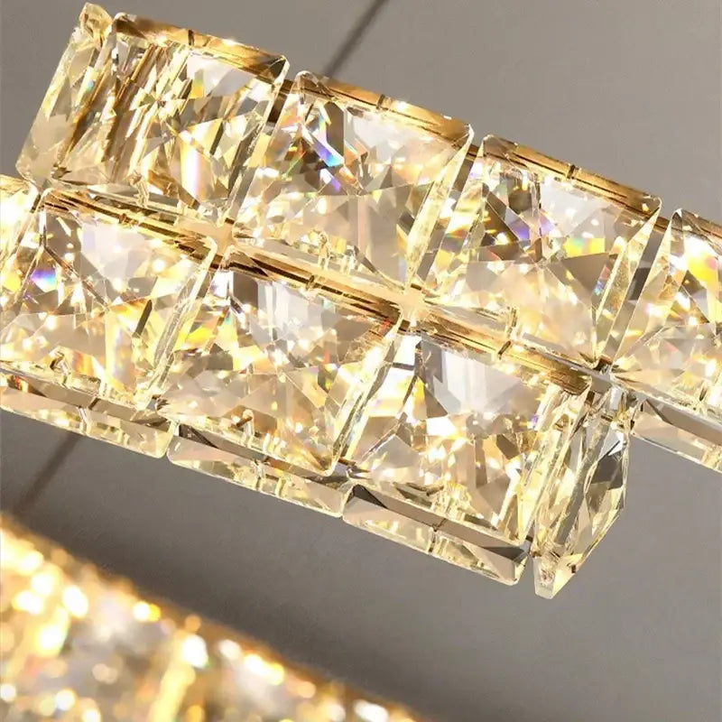 A modern decorbites crystal ceiling chandelier with golden faceted crystal squares in stainless steel frame for indoor use