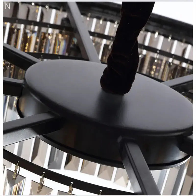 Black circular stool with matte finish and sleek modern design complementing decorbites crystal ceiling chandelier