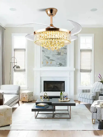 Gold-toned decorbites crystal ceiling fan with integrated crystal chandelier and white blades for bedroom or living room use