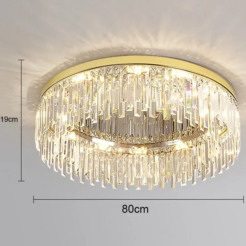 Gold-toned decorbites crystal ceiling lamp with cascading clear crystal prisms in a modern circular ceiling lamp design