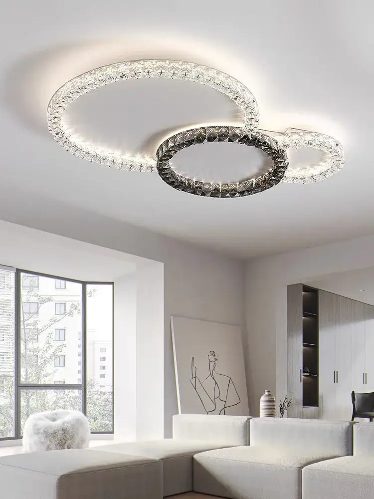 Modern decorbites crystal ceiling led chandelier with three interlocking rings and clear darkened crystals in metallic frame
