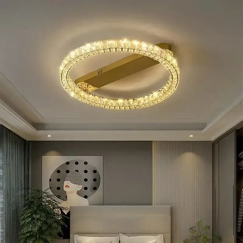 A modern decorbites crystal ceiling light with a gold metal frame and crystal elements emitting warm light
