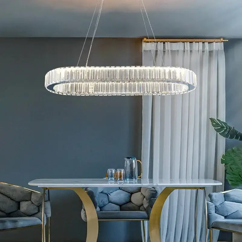 A modern oval-shaped decorbites crystal ceiling pendant chandelier with a sleek metallic frame for luxe room decor