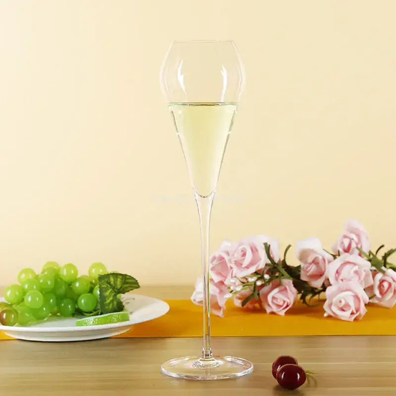 A tall clear decorbites crystal champagne flute filled with pale yellow liquid for elegant celebrations