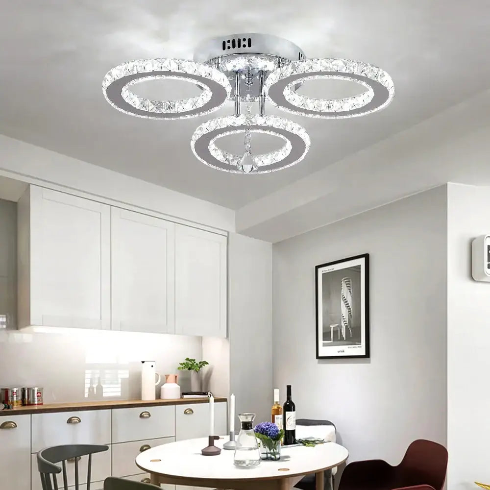 Modern chrome-finished decorbites crystal chandelier with three interlocking crystal rings and central pendant light