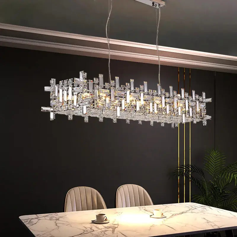Modern rectangular decorbites crystal chandelier with clear crystal prisms and led lights above marble dining table