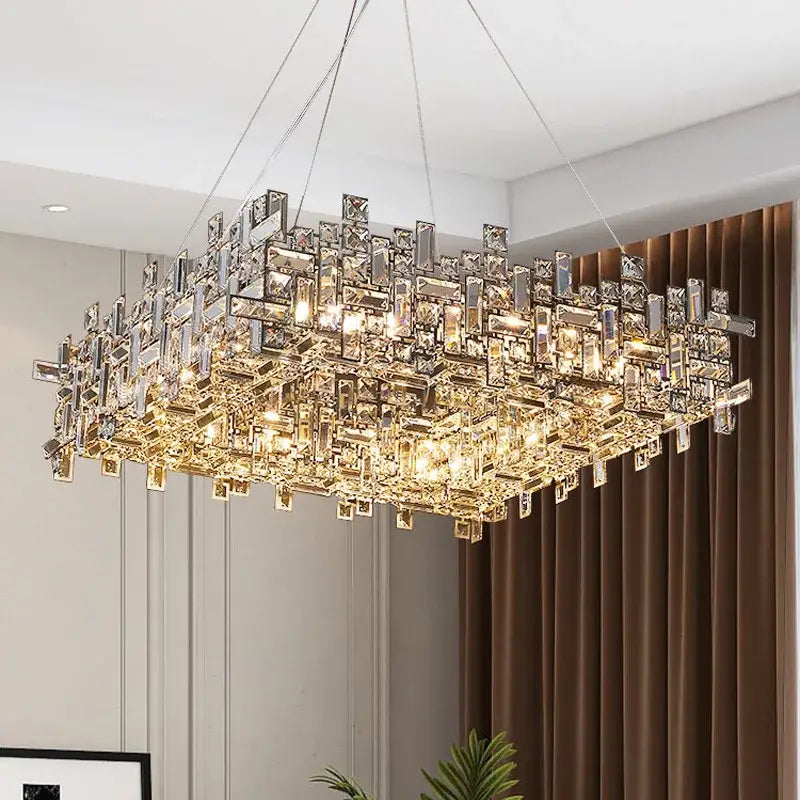 A decorbites crystal chandelier with clear and gold-toned crystal prisms in a modern rectangular design for luxury spaces