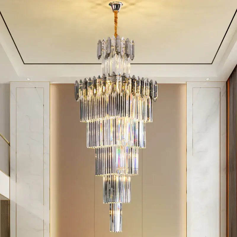 A multi-tiered decorbites crystal chandelier with cascading clear and frosted glass rods and gold-toned chain suspension