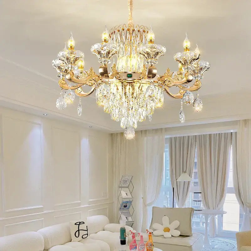 Gold-toned decorbites crystal chandelier with intricate crystal droplets and ornate arms lighting living spaces warmly