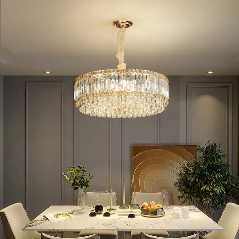 Luxurious gold-toned decorbites crystal chandelier with cascading clear faceted crystals and polished brass fixture