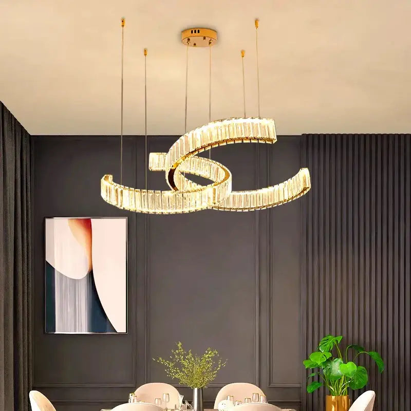 A modern gold-toned decorbites crystal chandelier with intertwined spiral design and embedded crystal accents for interior lighting