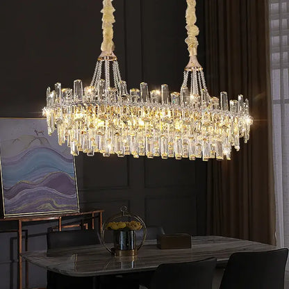 A luxurious decorbites crystal chandelier with cascading clear and golden prisms on cream metal chains for modern luxe homes