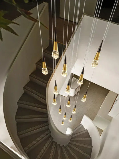 A decorbites crystal chandelier with gold-toned cone fixtures suspended above a curved staircase for dimming lighting