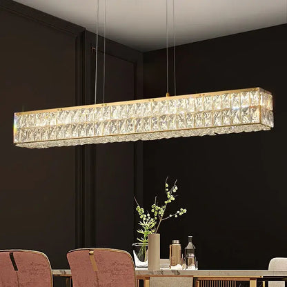 Rectangular decorbites crystal chandelier with gold-toned frame and faceted glass panels above dining table