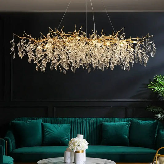 Golden leaf-shaped decorbites crystal chandelier with clear crystal droplets above teal velvet sofa for dining room