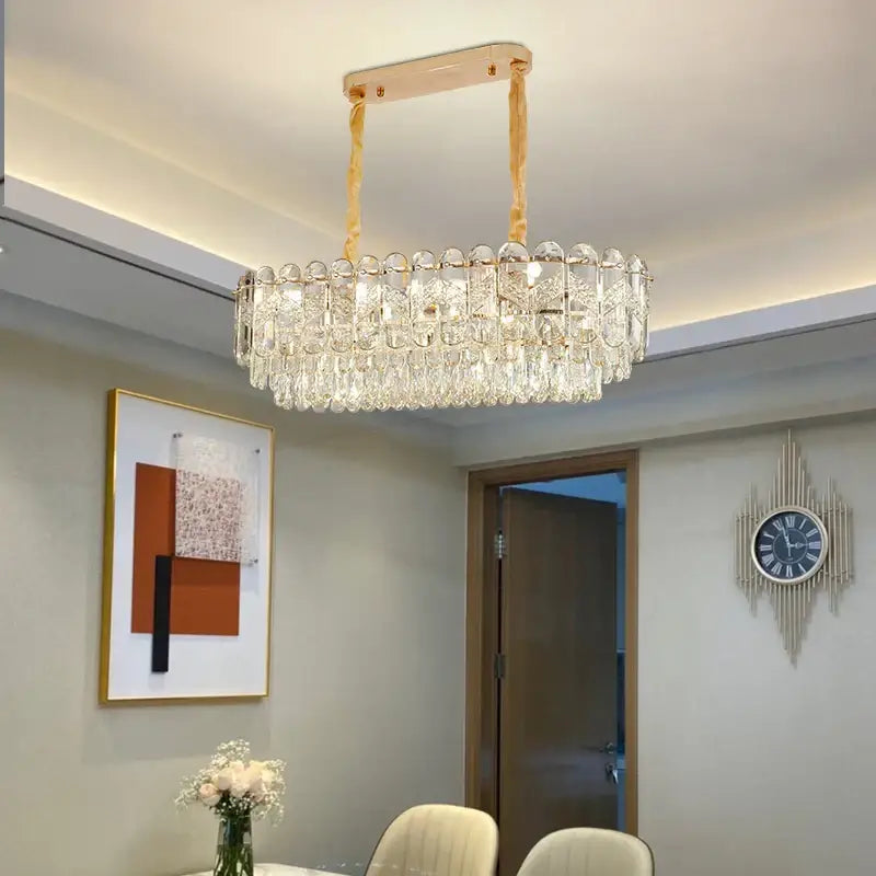 A modern gold-toned decorbites crystal chandelier with cascading clear crystal droplets for luxury lighting