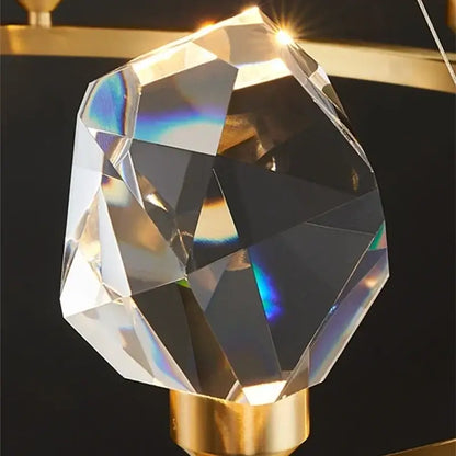 A faceted crystal chandelier led pendant light with a golden base refracting rainbow hues by decorbites