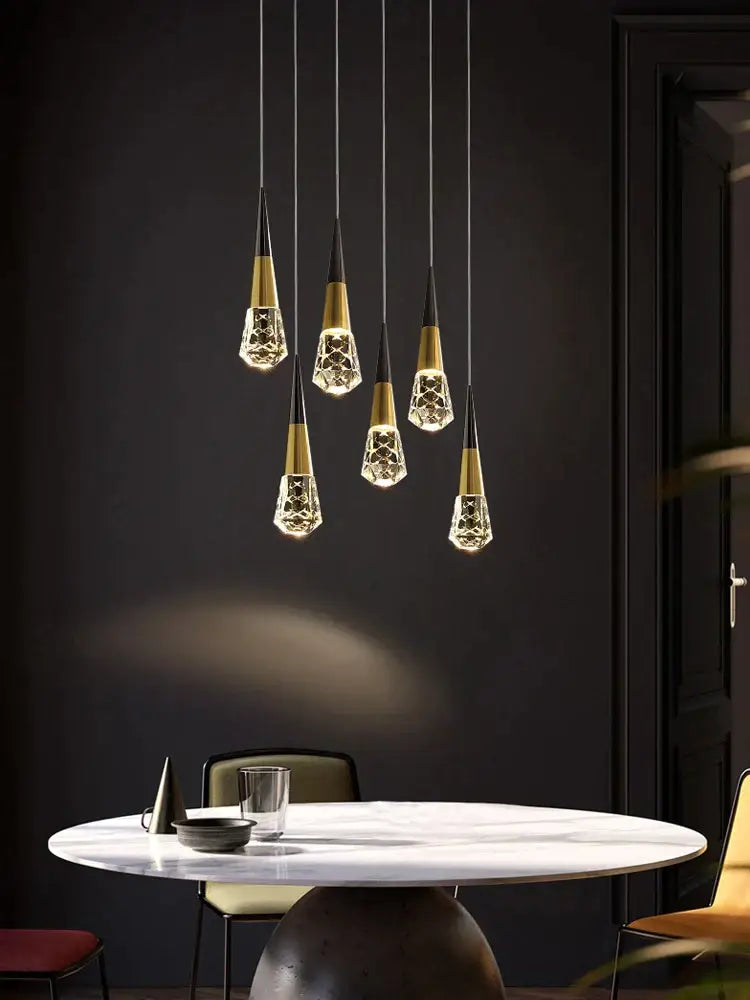 Five elegant gold and black decorbites crystal chandelier led pendant lights in a modern dining room setting