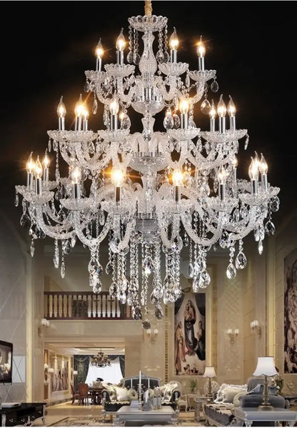 A multi-tiered decorbites crystal chandelier light with lit bulbs and teardrop crystals for luxury living spaces