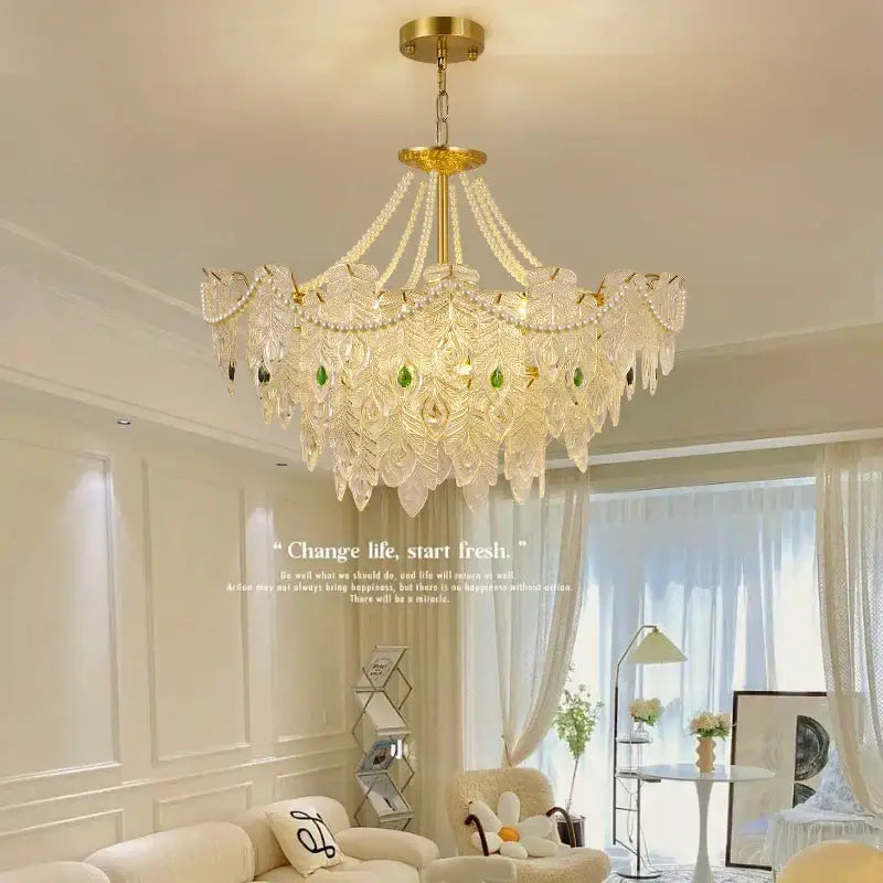 Elegant gold-toned decorbites crystal chandelier with cascading crystal leaves and green accent stones for luxury spaces