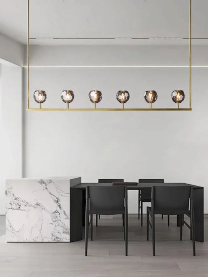 Gold-toned linear pendant crystal chandelier lights with six faceted glass globe bulbs for modern kitchen island decor