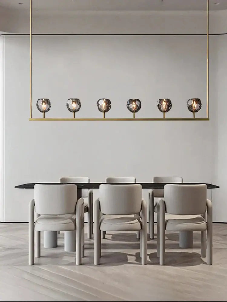 Gold-toned crystal chandelier lights with six spherical glass bulbs for modern kitchen island bar decor by DecorBites™