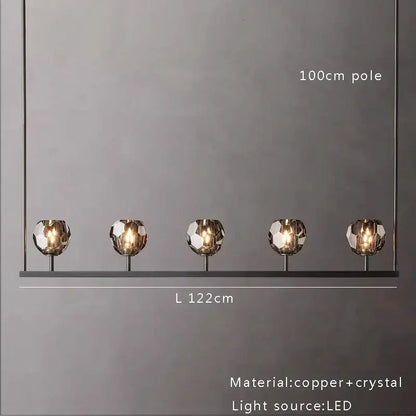 Modern five-light crystal chandelier lights with faceted crystal globes and copper accents for kitchen island decor