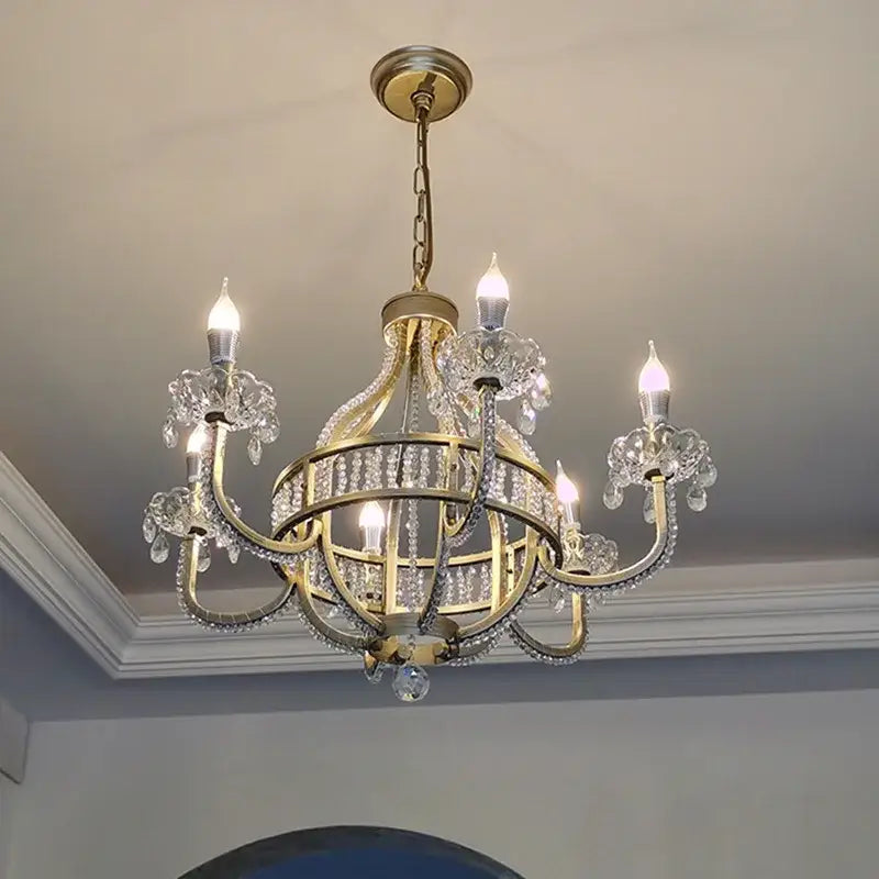 A gold-toned DecorBites crystal chandelier pendant light with crystal accents and five candle-style bulbs for luxe rooms