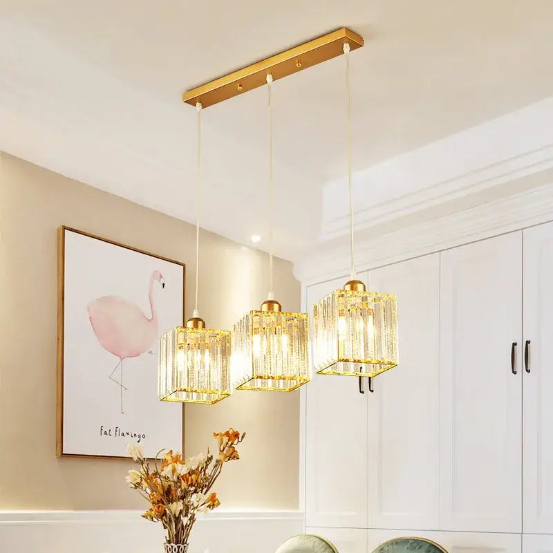 Gold-toned decorbites crystal chandelier pendant light with three crystal-encased square lamps for indoor use
