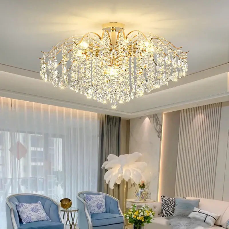Gold-toned decorbites crystal chandelier with cascading crystal droplets and central faceted crystals for romantic lighting
