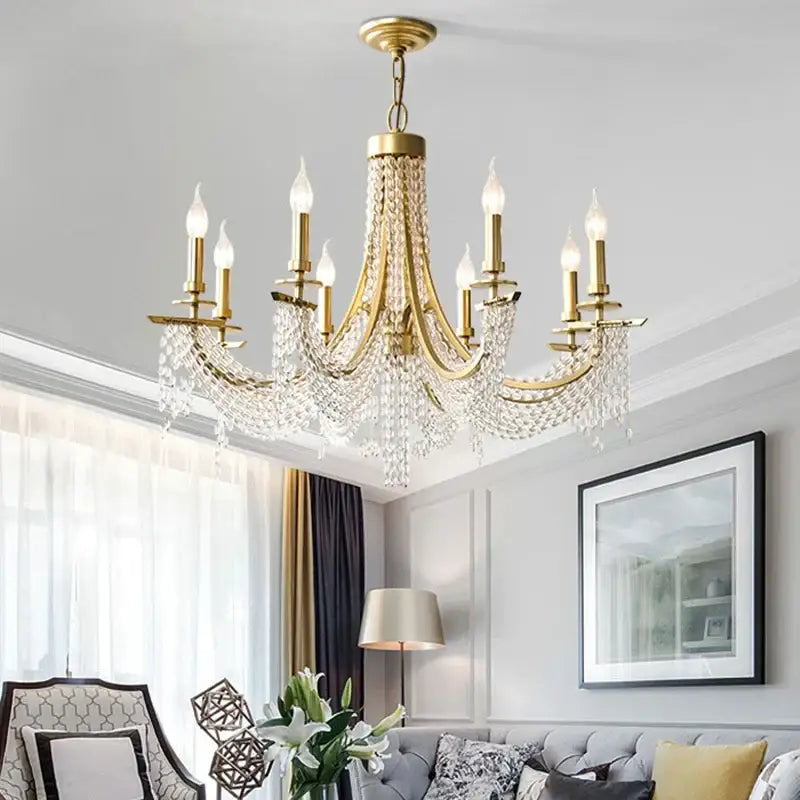 A gold-toned decorbites crystal chandelier with candle-style bulbs and cascading crystal droplets for romantic decor