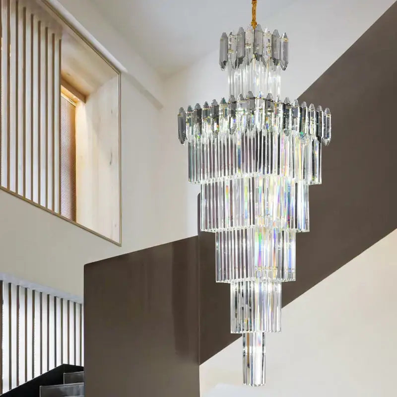 A decorbites crystal chandelier featuring multi tiered cascading clear and frosted glass rods with gold toned chain suspension