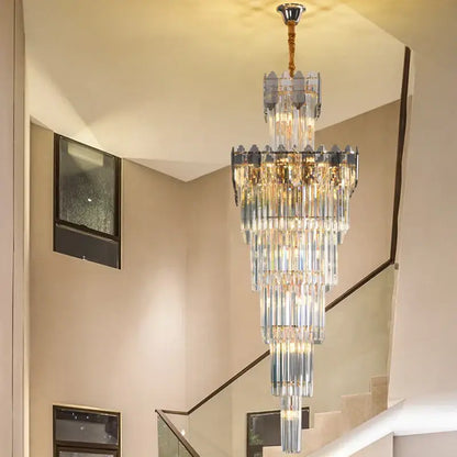 A multi-tiered decorbites crystal chandelier with cascading clear and frosted glass rods and brass ceiling mount