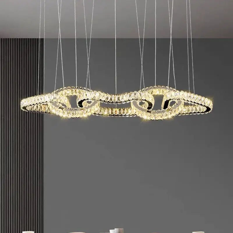 A modern decorbites crystal chandelier with interlocking crystal rings emitting warm light for luxury rooms