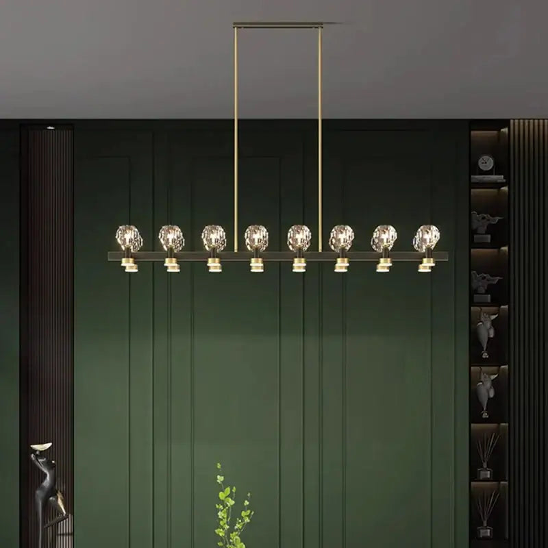 Gold-toned decorbites crystal chandelier with eight faceted globe lights on sleek metal frame for living and dining room
