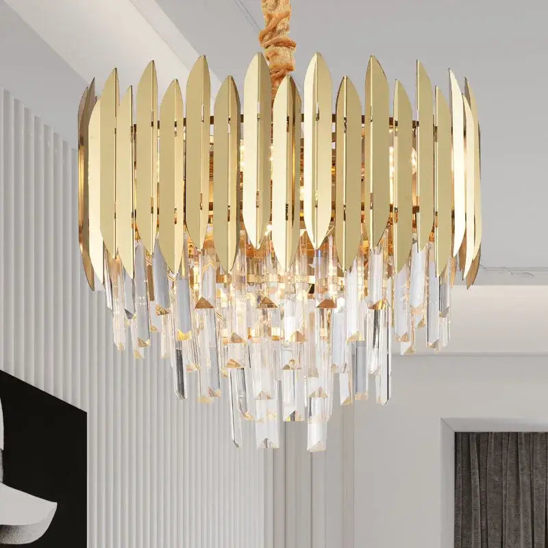 Gold-toned DecorBites crystal chandelier with vertical metallic blades and dangling crystal prisms for modern dining room lighting