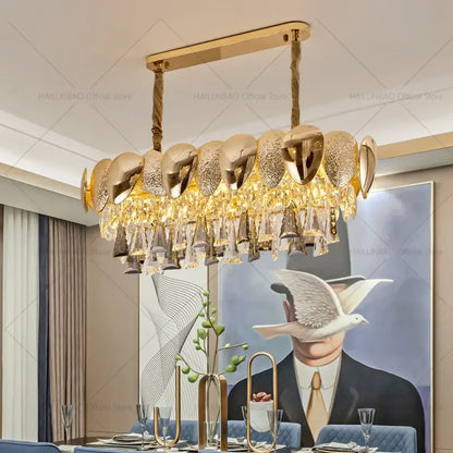 Gold-toned decorbites crystal chandelier with modern polished metallic shells and cascading crystal droplets for living spaces