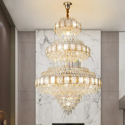 A multi-tiered decorbites crystal chandelier with gold-toned accents and cascading clear glass prisms for staircase lighting