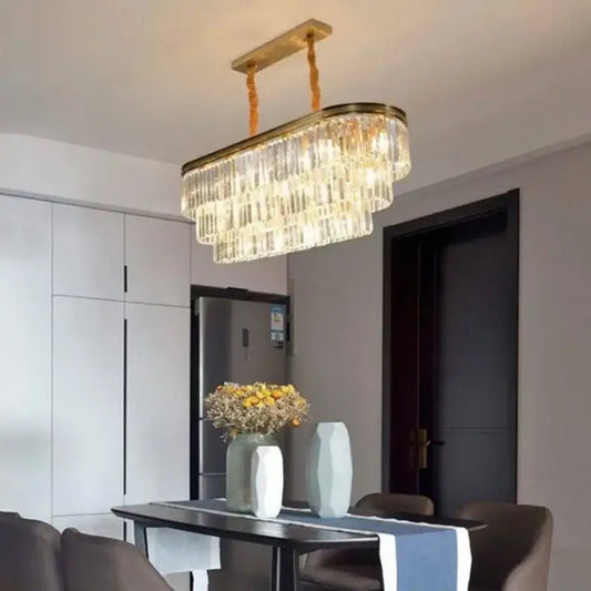 A modern decorbites crystal chandelier with gold-toned metal frame and cascading clear crystal prisms for interior lighting
