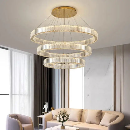 A decorbites crystal chandelier with three concentric rings of clear crystal rods and gold-toned mount for modern decor