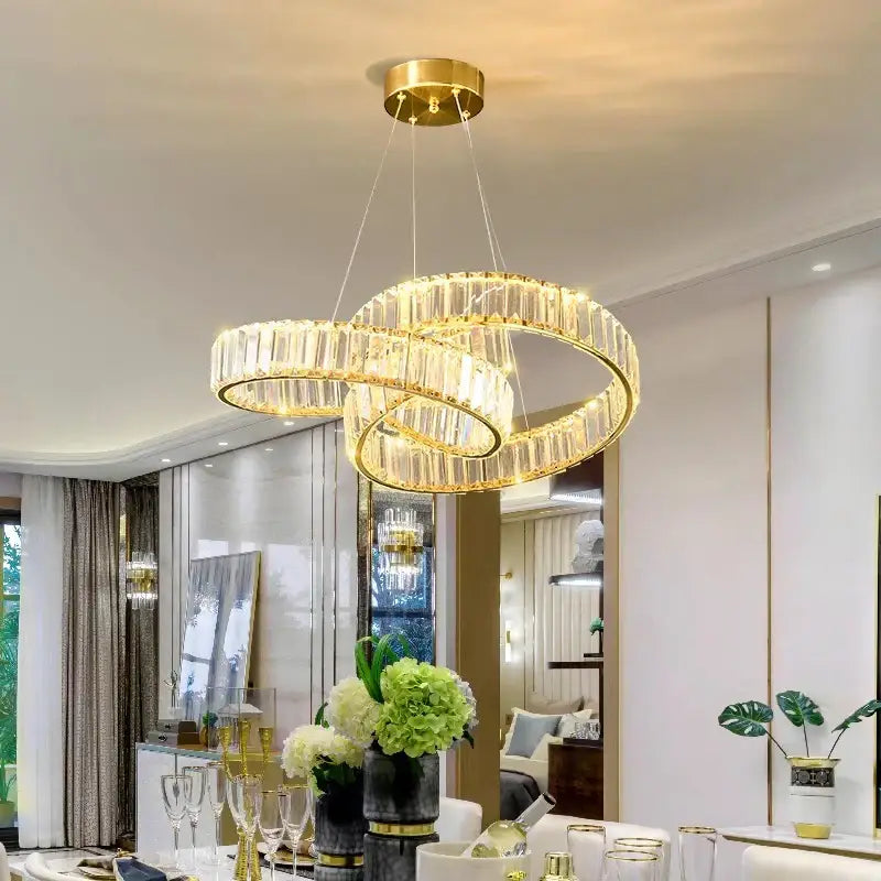 Gold-toned DecorBites crystal chandelier with interlocking rings and clear faceted crystals for modern interior lighting