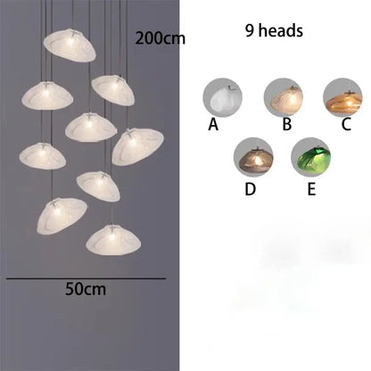 A decorbites crystal chandelier with nine translucent white shell-shaped lights hanging on thin cords for living room lighting
